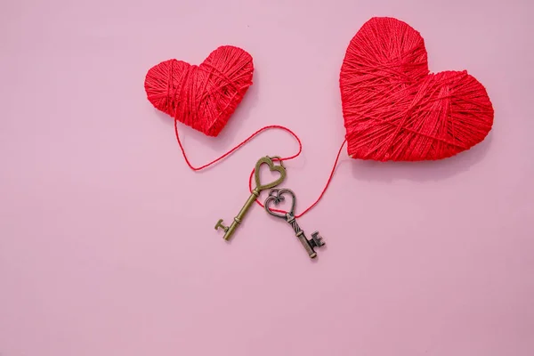 Coração vermelho decorativo e pequena chave de metal contra fundo rosa. Imagem romântica festiva para o Dia dos Namorados. Espaço para cópia. Feriados cartão postal sobre amor e sentimentos . — Fotografia de Stock