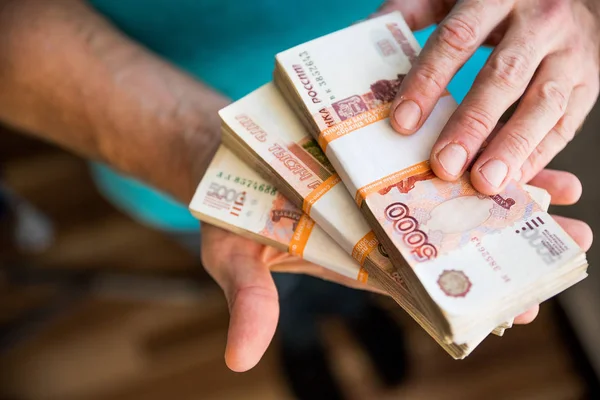 adam para, Rus Rublesi banknotlar, rüşvet ve yolsuzluk concept.russian ruble banknotlar üzerinde karanlık bir ofis - masasında vermek. Banknot finansal theme.stack bir el mans