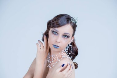 Genç kadın gümüş sanatsal makyaj ile yaratıcı görüntü. Tatil yapmak-up.Beautiful kadının Face.Winter Noel dudak makyaj ve saç stili ile taç. Yüksek moda portre kristaller ve taşlar.