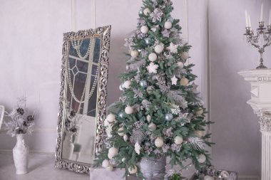 Büyük gümüş ve beyaz Noel ağacı hediye lüks iç ile dekore edilmiştir. Evde yılbaşı. Büyük ayna ve Noel dekorasyonu, iç Noel süsler. kış tatil oturma odası