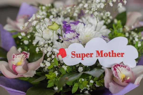 Feliz Día de las Madres. tarjeta de felicitación y hermosas flores. Vista de ángulo alto.Ramo de diferentes flores y orquídeas. Composición floral festiva —  Fotos de Stock