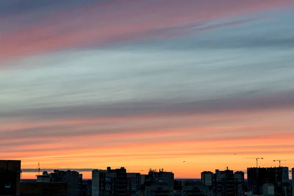 Vue d'ensemble de la ville et le coucher du soleil qui illuminent le ciel montrent la création d'art que la nature peindre le ciel et le nuage avec une couleur de ton chaud en contraste avec le ciel bleu. — Photo