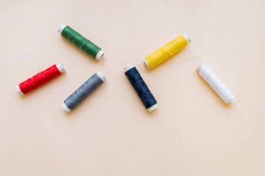 pastel arka plan üzerinde çeşitli dikiş ipliği topluluğu. her biri ayrı ayrı vurulur. knittinng araçlar. Doğal pamuk dize izole rulo, uzay kopyalayın. Nakış renkli renkli iplik bobinleri multi