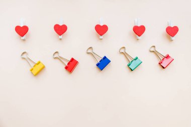 desen renkli bağlayıcı klipleri ve pastel kağıt background.binders sette kırmızı kalpler. Kırtasiye Ofis işleri için araçlar. Space.Business yaratıcılık kavramları kopyalayın. Düz yatıyordu tasarım