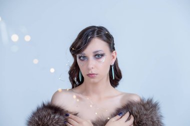 Yukarıya bakıp kürk şapka Kış kadın rüya. Güzel seksi kadın modeli ile lüks kürk coat.bare omuz yaratıcı makyaj moda portre. Kış moda Satılık. Lüks esmer