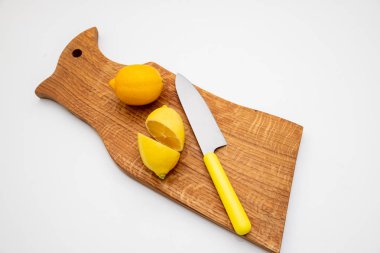 Taze limon bir kesme tahtası. Bir knife.Composition lezzetli Narenciye meyve Ahşap Doğrama tahtası üzerinde sarı limon yarısıyla. Taze mojito içecekler ile limon, limon. Uzay kopyalayın. Dilimlenmiş ve bütün