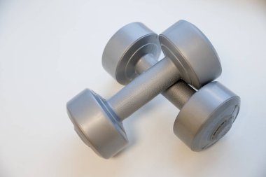 Beyaz arka plan üzerinde iki Bayan halter. Sağlıklı şekli ve spor kavram. Şekillendirme ve fitness ekipmanları. Gri plastik dambıl. Küçük size.dumbbells Barbell ısınma için kullanılabilir