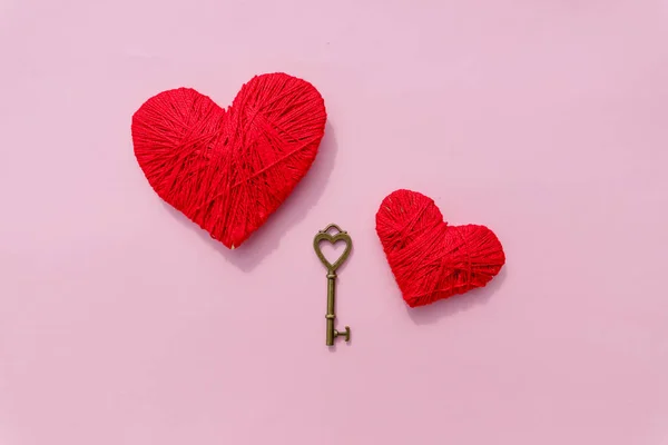 Happy Valentijnsdag achtergrond met twee harten op roze background.thread geïsoleerd op white.knitting concept. Rode en roze hart vorm symbool gemaakt van wol. Vintage sleutel en rood hart. — Stockfoto