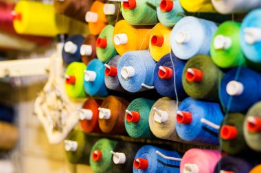 Renkli koni ve iplik bir atelier, makaralar. , Hazır giyim endüstrisi, tasarımcı atölye kavramı terzilik. nakış iş parçacığı spool.row çok renkli iplik rulo, dikiş malzemesi. Terzi İşyeri
