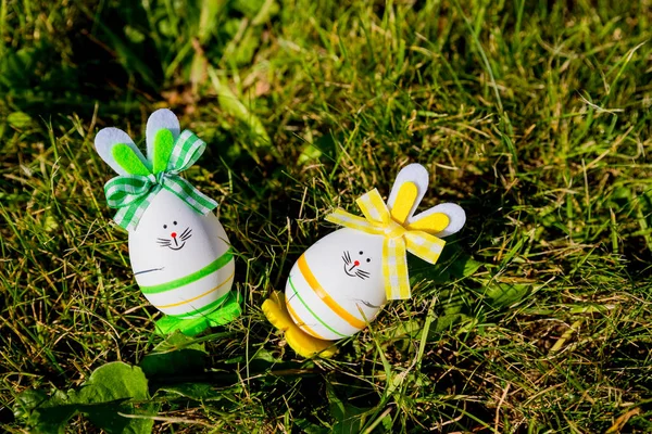 Carino foto creativa con uova di Pasqua come il coniglietto di Pasqua su sfondo erba verde. Buon biglietto di auguri pasquale Un Coniglietto Uovo di Pasqua.Concetto di vacanza pasquale con due simpatiche uova fatte a mano: coniglietti — Foto Stock