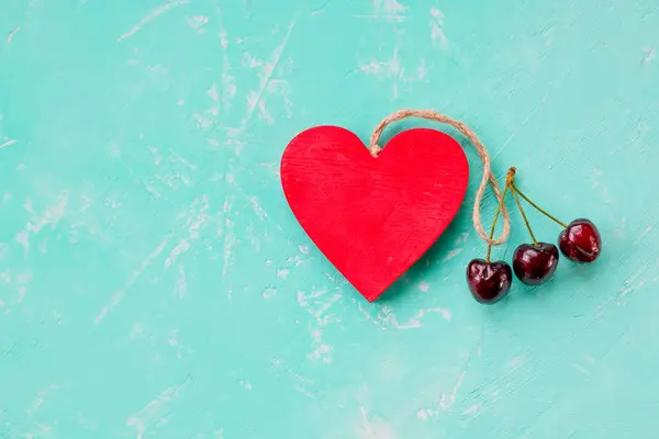 De dag van Valentijnskaarten, verrassing cadeau met red Cherry. Gezonde voeding. Rode bessen kersen, houten hart. Zomer liefde, stilleven op pastel achtergrond. Plat lag, Top uitzicht. Kopieer ruimte. liefde van kers. Romantische — Stockfoto