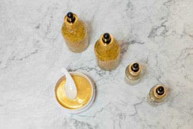 Spa kozmetik yukarıdan beyaz mermer zemin üzerinde. Güzellik blogger kavramı. Copyspace.Beauty cilt bakım ürünleri. yağ, krema, serum, hidrojel altın kozmetik göz yama kavanoz.