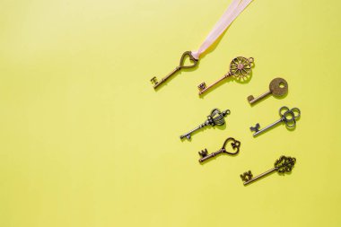 Koleksiyon vintage anahtarları izole. Üstten görünüm. Antika tuşları üzerinde sarı arka plan düz yatıyordu desen izole. Yaratıcı dekoratif arka plan tasarımı için. Retro tarzı