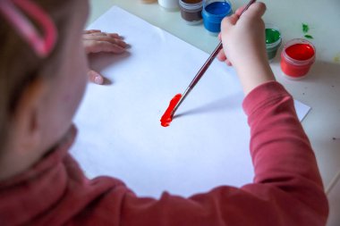Guaj ve su resim ve çocuk artwork.the çocuk yapıyor beyaz paper.child üzerinde çizim için paint.kindergarten, eğitim kavramı onun fırça daldırma. Paintbrush resim çizim çocuğun el