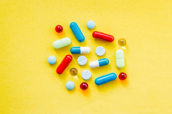colorful pills and drugs in close up.assorted pills and capsules in medicine. drugs of various kinds and different colors. Medicine on yellow background