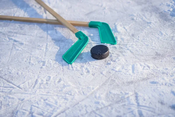 Palo de hockey sobre hielo con cinta blanca y disco. juego de equipo, concepto de competencia en business.Ice palos de hockey y disco sobre fondo blanco aislado, equipo para los niños jugador de hockey en temporada de juego de invierno — Foto de Stock