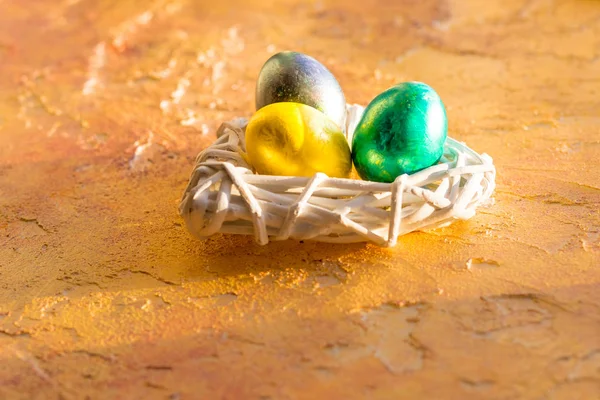 Bright, colorful Easter eggs in isolated on yellow.Background, multicolored easter eggs.Tree easter eggs in white nest — Stock Photo, Image