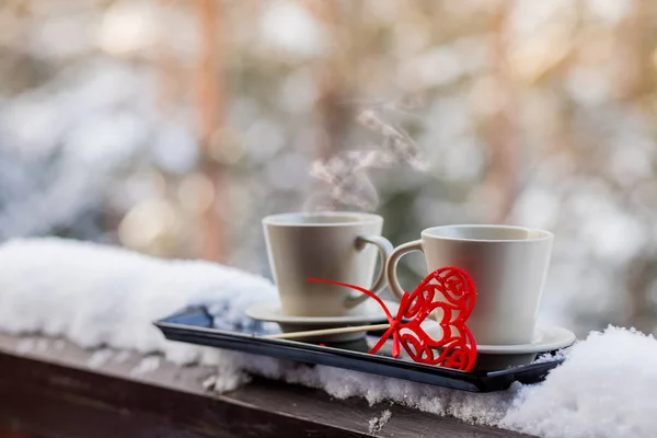 Valentines day concept - two cups of tea,coffee,hot drink in front of snow background.two cups with hot coffee on the background of the winter forest. decorations for Valentines Day or wedding.Copy — Stock Photo, Image