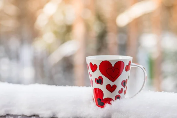 Valentines Day with red cup coffee on snow white background, copy space Valentine Concept.Warm and romantic atmosphere in a cold winter Valentines Day. Hot drinks outdoor. — Stock Photo, Image