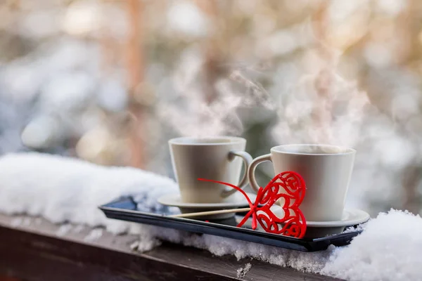 Tazas de té o café con vapor, forma de corazón sobre fondo borroso. Celebración del día de San Valentín o concepto de amor. Copiar space.love y café, bebidas calientes al aire libre, en Balcón, terraza, patio.Romantic — Foto de Stock