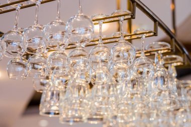 Sarı ışık Ampüller yukarıda parlayan cam raflar içinde bir kulüp veya lokanta bar asılı metal farklı gözlük gözlük görüntü bar.selective focus.horizontal düşük açılı üzerine asılı yığılmış