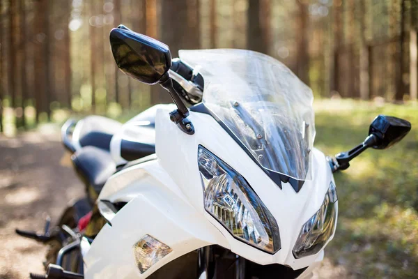 Beyaz motosiklet, direksiyon simidi. güneşli havalarda. ormanda moto turizm ve Rekreasyon kavramı, farlar bir motosiklet yakın çekim, motosiklet, motosiklet parçaları