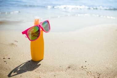 Çeşitli sunsreen ürünleri kum. Kozmetik Şişeler için kişisel bakım beach background.protect cildi uv ışınları üzerinde izole. Sprey güneş koruyucu, losyon veya güneş kremi için vücut için güneş ışınlarından Uv önlemek