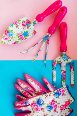 Bahçede mavi background.working metal Bahçe aletleri ve lastik Emanet eldiven üzerinde pastel pembe. El küreği ve eldiven ile Bahçe komisyon. Tarım ve Bahçe kavramı. Çatal ve komisyon maça. Bahar