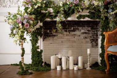 Zarif gri tuğla şömine çiçekler ve mumlar dolu. Zarif oda. Düğün alan dekore edilmiştir. Vintage dekor iç. romantik şömine bahar çiçekleri, çelenk, candles.brick duvar ile dekore edilmiş