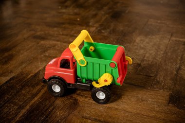 Büyük bir plastik oyuncak kamyon izole ahşap arka plan. Erken eğitim için renkli oyuncak kamyon. Çocuklar game.toy araba. Ulaşım çocuklar için oynayın ve anaokulu concept.role oyunda öğrenin