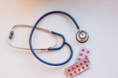 Eczane arka plan üzerinde beyaz bir tablo. Tablet, hap. Tıp ve sağlıklı. Bir doktor tarafından ilaçların reçete kavramı. Stetoskop ve tıp Tablet.