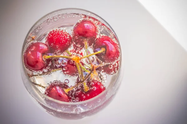 Cerejas na água com bolhas, coquetel de Cereja - na água de carbonato de sódio. Bebida fresca de verão. Espaço de cópia — Fotografia de Stock