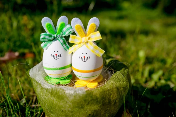 Funny décorations lapin oeuf de Pâques lapin dans l'herbe verte carte postale vacances background.kids chasse pour l'oeuf de Pâques dans le jardin de printemps en fleurs le jour de Pâques. — Photo