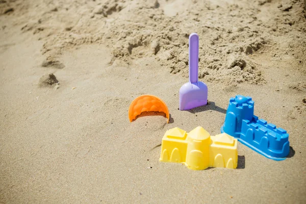 Bright plastic childrens toys in the sand. Concept of beach recreation for children. Kids summer games. Summer concept. copy space.family summer holiday at the seaside — Stock Photo, Image