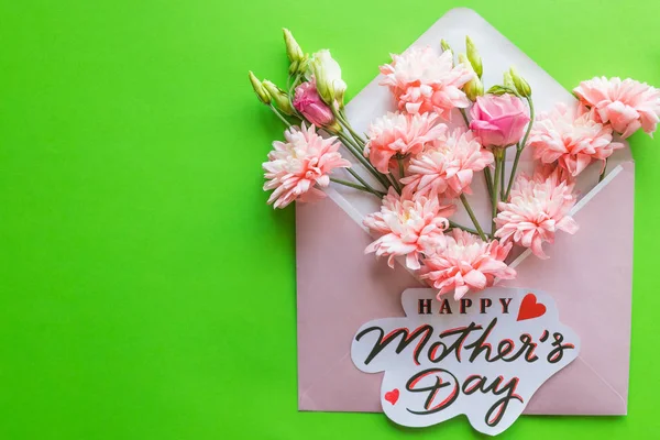 Bir buket pembe çiçekler, lisianthus, krizantem yeşil bir arka plan üzerinde. Mutlu anneler günü kartı. Bahar Bouquet.Pink kasımpatı çiçekleri ile tebrik kartı. Mutlu anneler günü Pastel şeker renkleri
