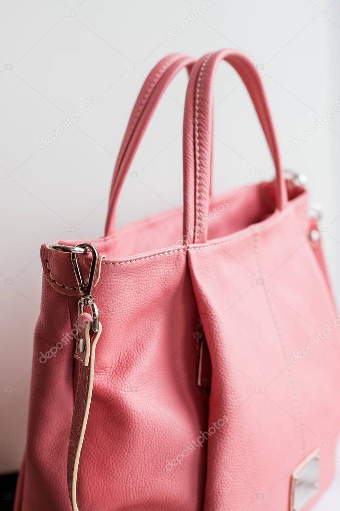 Stylish womens accessories. Beautiful womens handbag of Living Coral color on a white background. Light pink, light coral.woman fashion accessories.Large purse handbag
