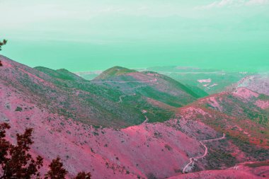 görkemli bulutlu manzara.güneş ışığında parlayan yeşil bulutlar. Dağlar ve yollar. yaratıcı görüntü. Yeşil gökyüzü ile soyut futere manzara