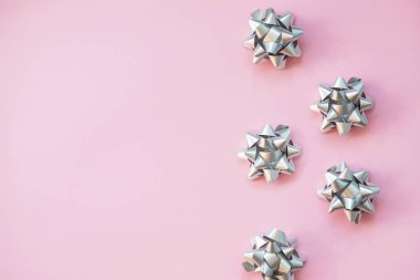 Pembe pastel masa üst görünümünde dekorasyon için moda yay. Düz Doğum günü, Noel veya düğün için kompozisyon yatıyordu. pembe üzerinde izole gür yay. Metalik yay, trendy arka planda tatil hediye dekorasyon