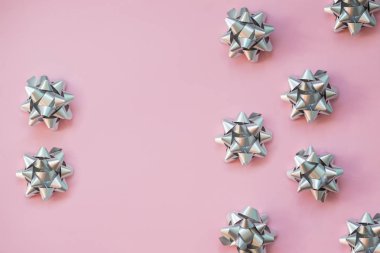 Pembe pastel masa üst görünümünde dekorasyon için moda yay. Düz Doğum günü, Noel veya düğün için kompozisyon yatıyordu. pembe üzerinde izole gür yay. Metalik yay, trendy arka planda tatil hediye dekorasyon
