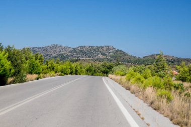 Yol ve açık doğal Landscape. Empty dağ asfalt yol Korfu Adası, Yunanistan. Geniş açılı lens çekimi. Ormanlık dağlarda boş asfalt yol karayolu. Parlak güneşli bir günde Carefree sürüş
