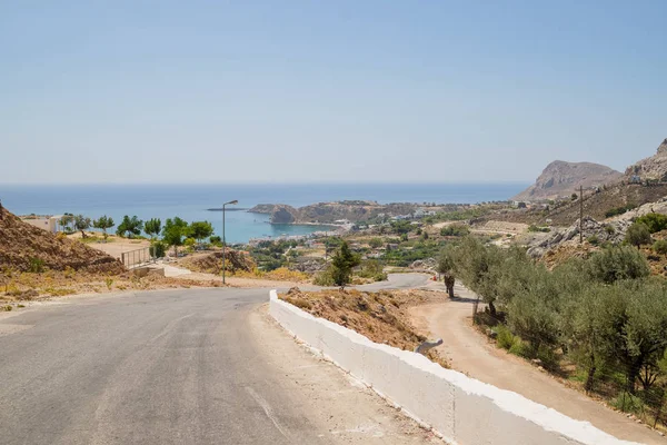 Közúti és kültéri természeti tájkép. üres hegyi aszfaltút Korfu szigetén, Görögországban. Nagy látószögű objektív shot. Üres aszfaltút autópálya az erdős hegyekben. Gondtalan vezetés a fényes napsütéses napon — Stock Fotó