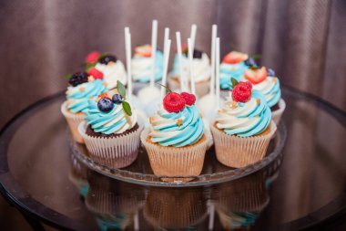 Çilek ile lezzetli cupcakes. Buttercream ve taze ahududu, yaban mersini.özel tatil kutlama olay ile renkli cupcakes. Çocuk partisi.şenlikli masa