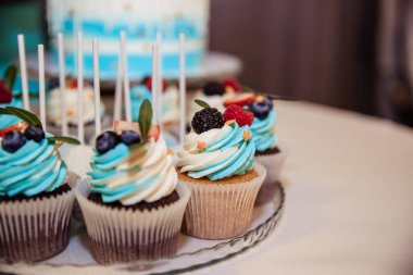 Çilek ile lezzetli cupcakes. Buttercream ve taze ahududu, yaban mersini.özel tatil kutlama olay ile renkli cupcakes. Çocuk partisi.şenlikli masa