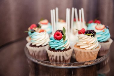 Çilek ile lezzetli cupcakes. Yemek afişi. Yaban mersini krema ve çilek ile Vanilya cupcakes. Close. Seçici odak. Lüks catering konsepti.peynir kremalı cupcakes