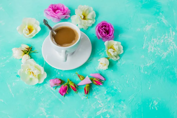 Delicioso café espresso fresco por la mañana con una hermosa crema gruesa en el fondo de la mesa de color azul con burbujas brumosas brotes de rosa en él, lay.cup plana de café, rosas flores.Copiar el espacio —  Fotos de Stock