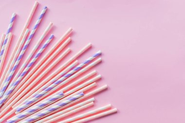Pembe arka planda izole kağıt tüpler ile bir afiş için arka plan. Kokteyl tüpleri ile bir afiş için çerçeve. Parti afiş, kokteyl bar. Zarif beyaz çizgili kağıt Içme pipetler