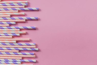 Pembe arka planda izole kağıt tüpler ile bir afiş için arka plan. Kokteyl tüpleri ile bir afiş için çerçeve. Parti afiş, kokteyl bar. Zarif beyaz çizgili kağıt Içme pipetler