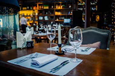 Gözlük, çiçekler, çatal, bıçak rahat iç mekan, Retro Film filtre efekti ile restoranda akşam yemeği için servis. Seçmeli odak. Restoran İç, modern ayar, şarap gözlükleri, tekstil peçeteler üzerinde. Kavram