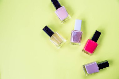 Tırnak cilası ile çok renkli şişeler sarı bir arka planda koydu. Oje bir şişe. Güzellik Salonu. Trendy şık renkli çivi, nailpolish. manikür güzellik tedavisi
