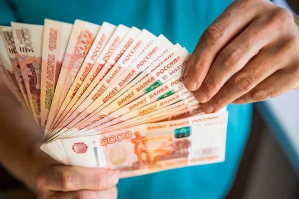 Para sayan işadamı, Rus Rublesi para birimi. finansal ve zengin kavramlar. Erkek elinde 5000 ruble yeni banknotlar.yatırım, yığın sikke ile tasarruf, Mortgage kavramı